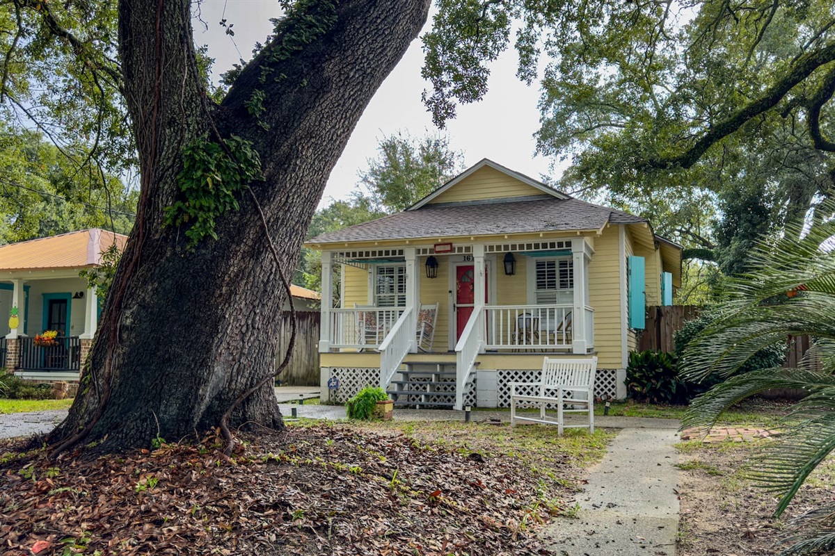 Adorable coastal cottage with a welcoming front porch, shaded yard, and classic Southern charm.