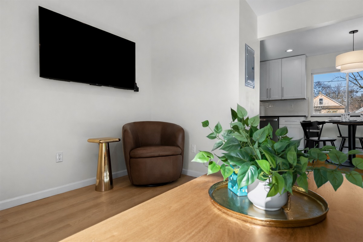 Cozy lounge corner with a comfortable accent chair, smart TV, and warm finishes—an inviting spot to relax after a day out.