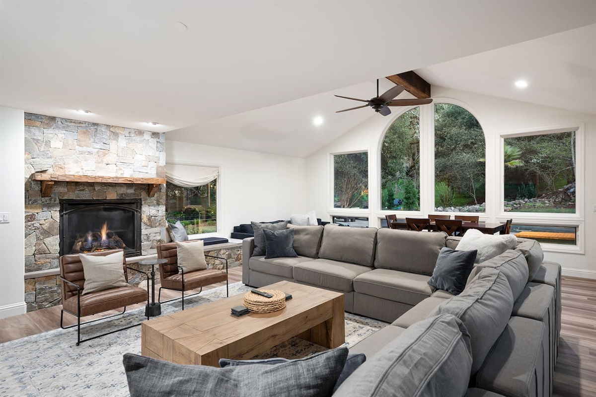 Giant sectional and accent chairs open to the gas fireplace and 80" 4K TV. Comfortably seat 12 adults for a movie night!