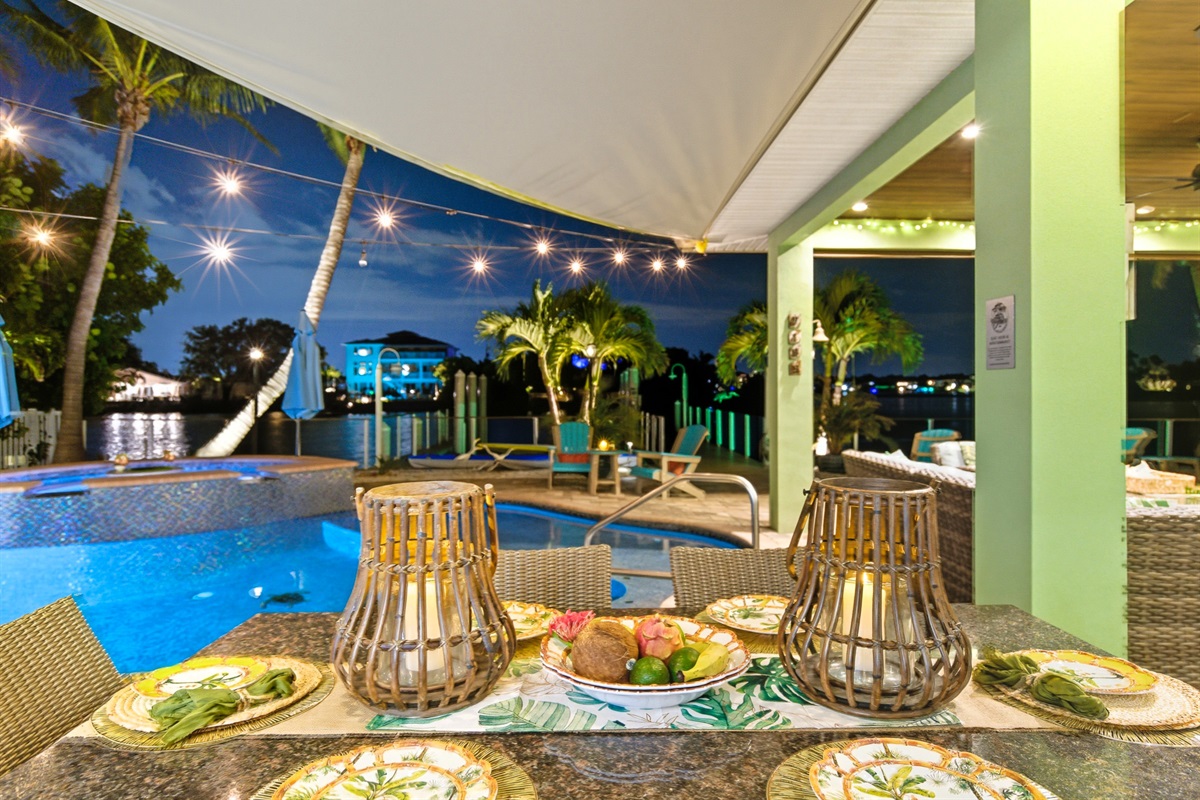 The outdoor dining table is under the lanai for covered meals.