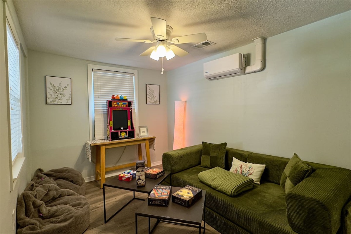 Fun, cozy game room with plush seating, board games, and an arcade-style setup for laid-back entertainment.