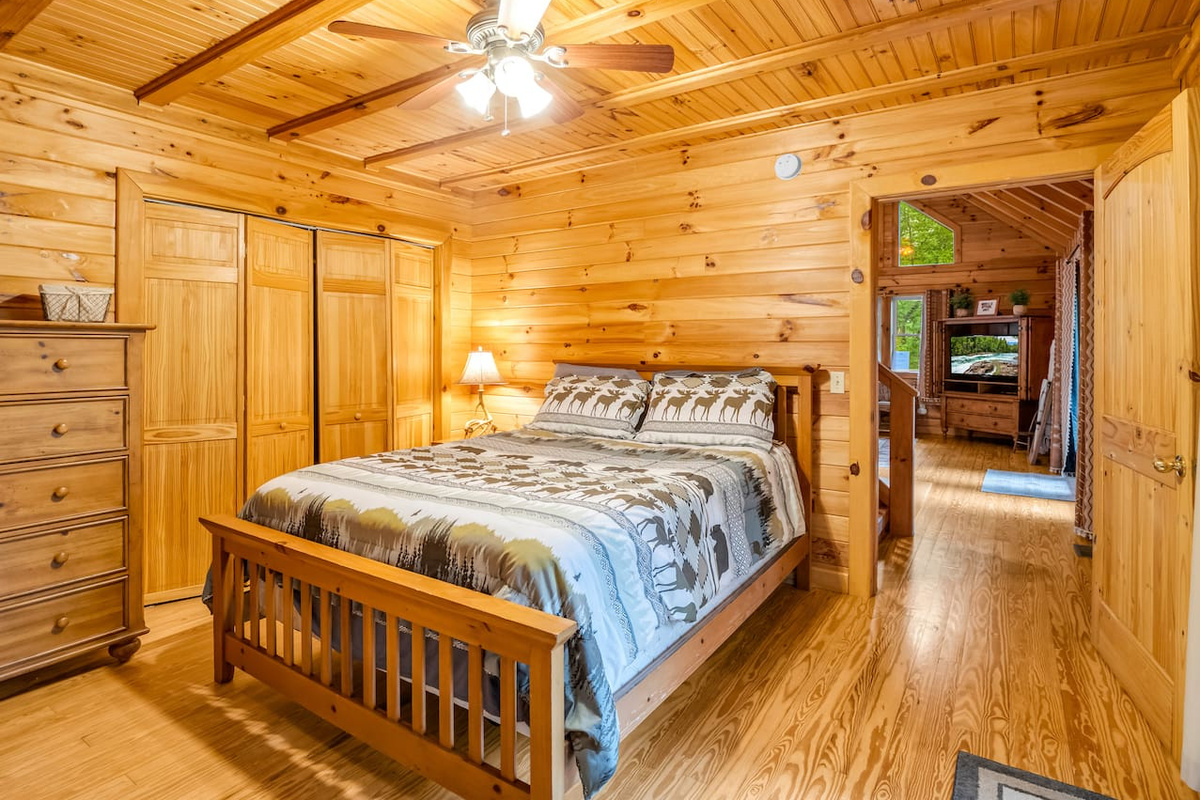 Cozy main-level bedroom with a cozy double bed, rustic wood finishes, and plenty of storage space