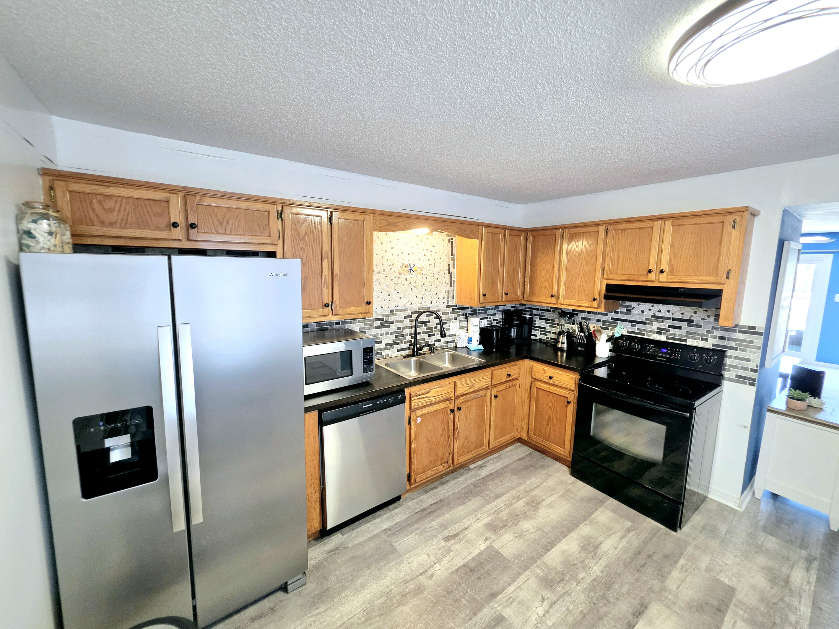 Hideaway side – Kitchen with stainless refrigerator and dishwasher