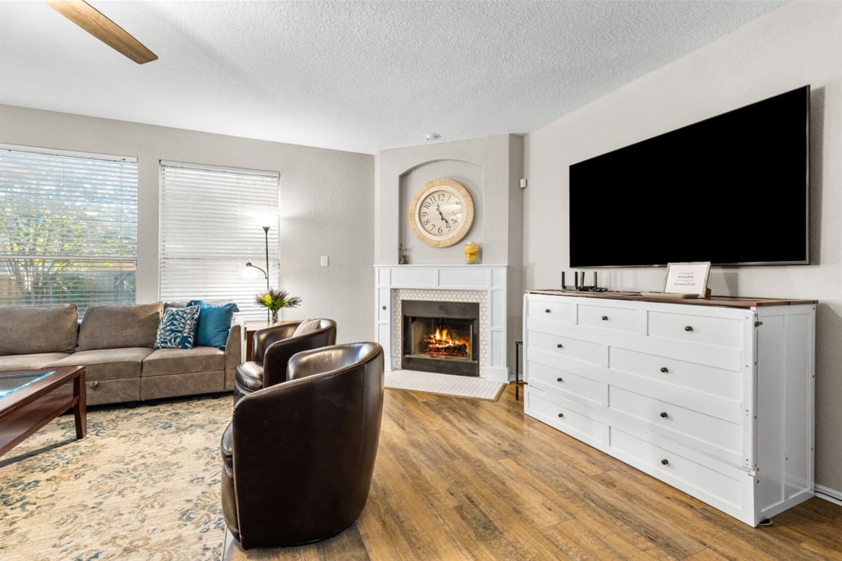 Bright and cozy living room featuring a Smart TV with streaming, comfortable seating, and a pull-out dresser bed for extra guest accommodations.