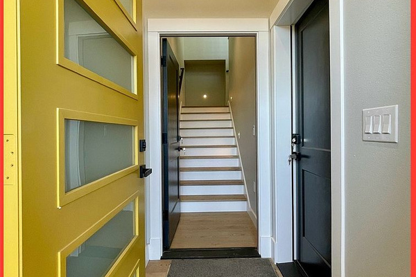 A bright, welcoming entryway with a pop of color — drop your bags here, then head upstairs to the main level.
