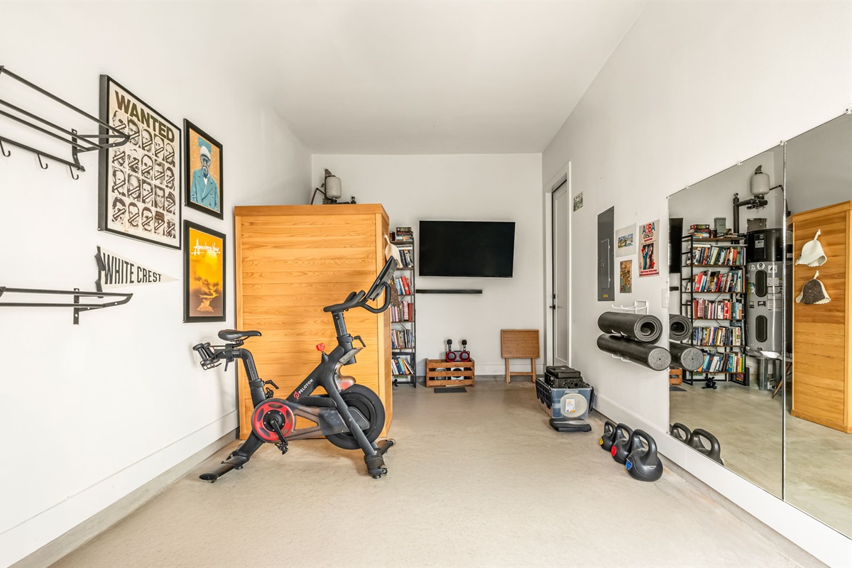 Private home gym with cardio equipment, weights, and workout space