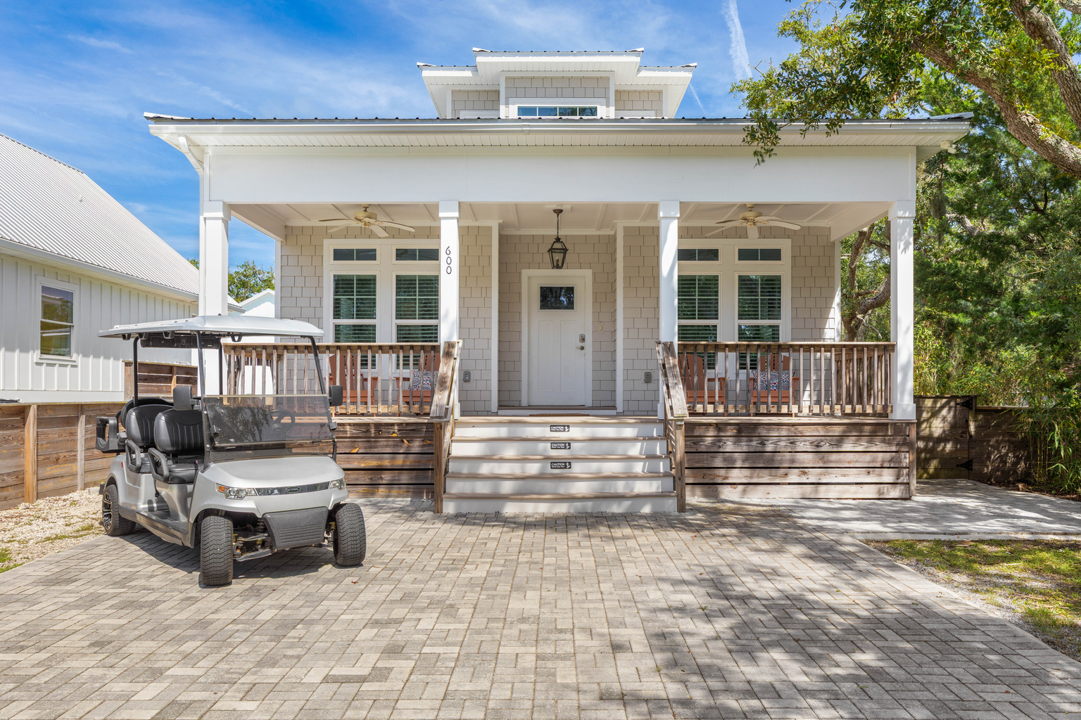 Number 600, and by the second day you will spot it from the end of the street. The cart waits under the oaks, the porch fans are already turning, and these front steps become the meeting point for every outing.