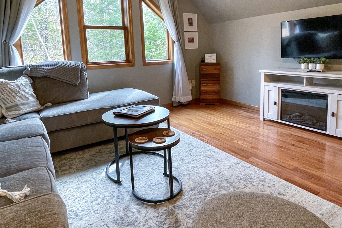 Upper level main living room with large windows electric fireplace open concept to kitchen. Queen sleeper sofa pull out memory foam mattress. 