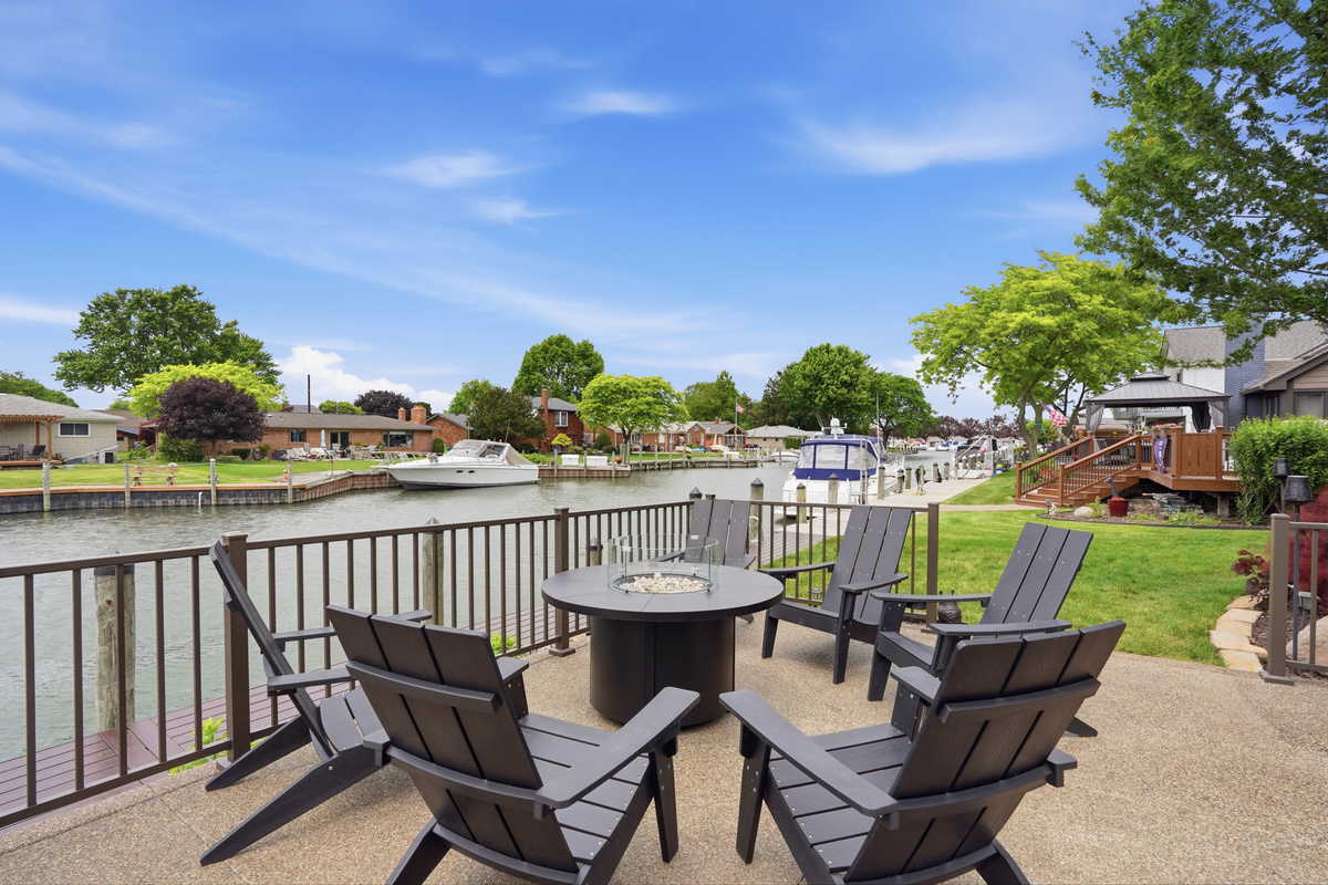 Waterfront seating area with fire pit and canal views—perfect for relaxing, socializing, and enjoying peaceful lakefront living.