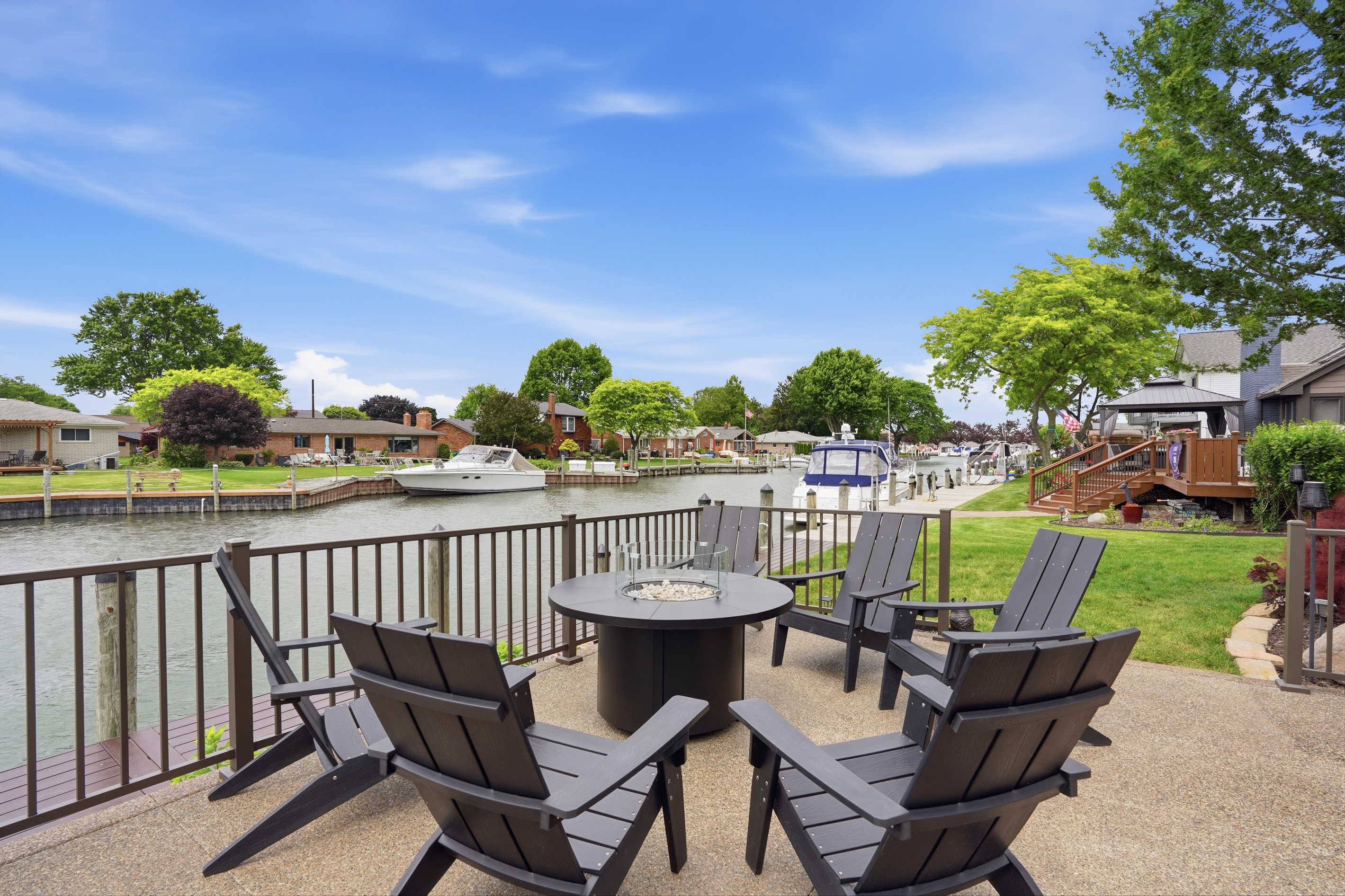 Waterfront seating area with fire pit and canal views—perfect for relaxing, socializing, and enjoying peaceful lakefront living.