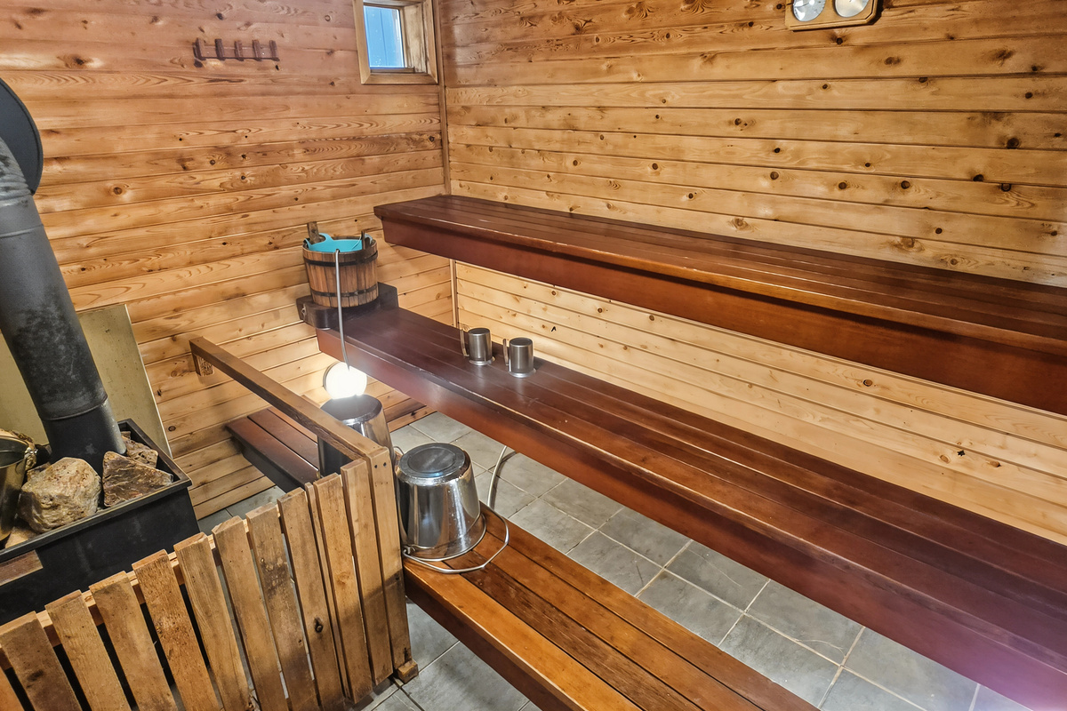 Sauna interior showing wood stove and benches