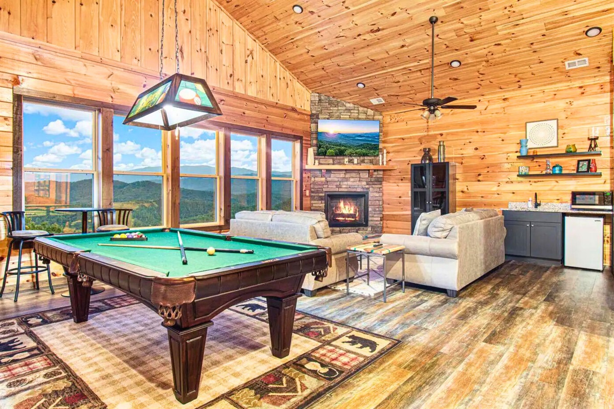 Upstairs Lounge Area with Large Open Windows, Pool Table, Fireplace and Seating and a Wet Bar