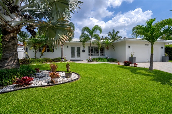 Beautiful tropical front yard with lush landscaping and private driveway