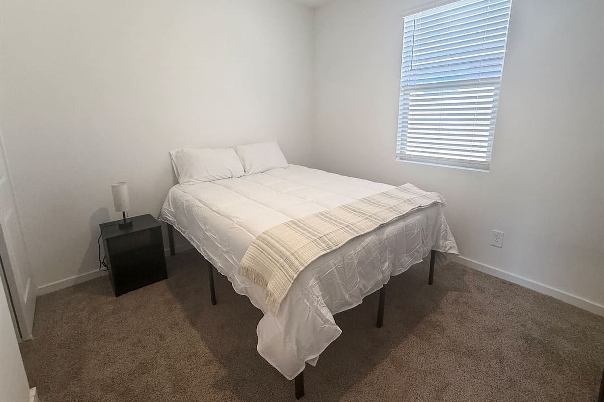 Bedroom with bed, nightstand, and window