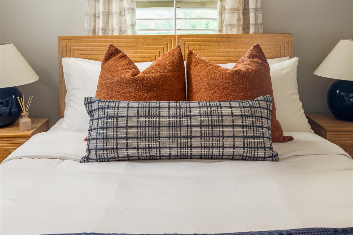 Plush bedding layered with contrasting pillows adds just the right touch of texture and comfort.