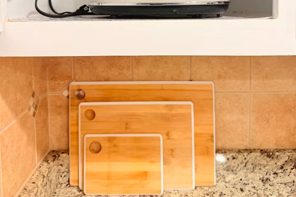Organized kitchen drawers and shelves keep essentials like cookware, cutting boards, and utensils easily accessible. 