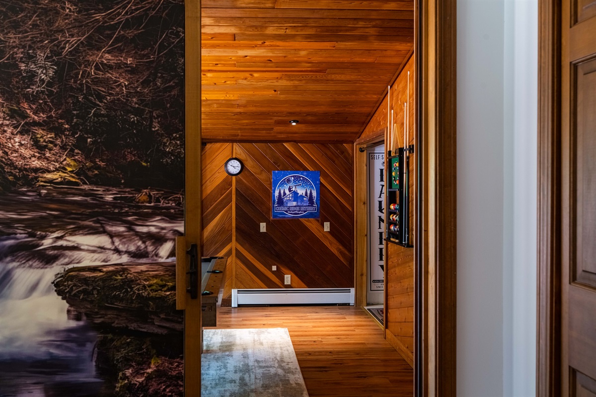 Step into the lower level, where warm wood paneling creates a rustic yet stylish vibe.