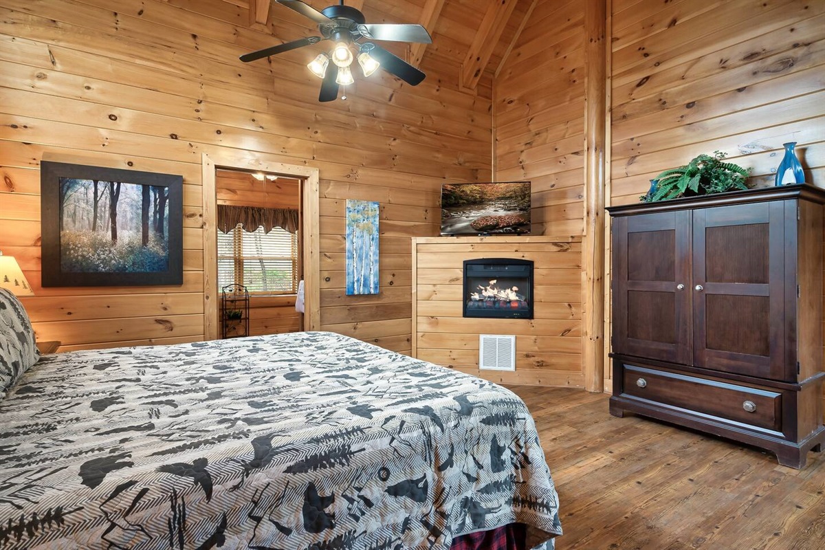 King size bed in upstairs master suite.Armoir, fireplace, and TV pictured as well.(Fireplace is electric and for decorative purposes only)