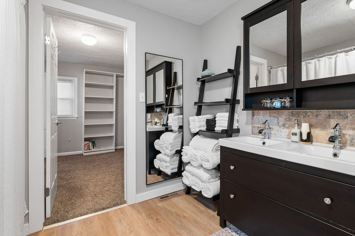 Private primary bathroom with a combination tub and shower, towels, and toiletries.