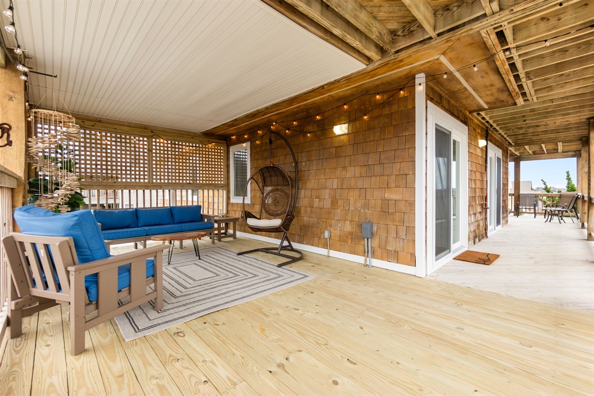 Spacious covered deck with multiple seating areas and a relaxed setup.