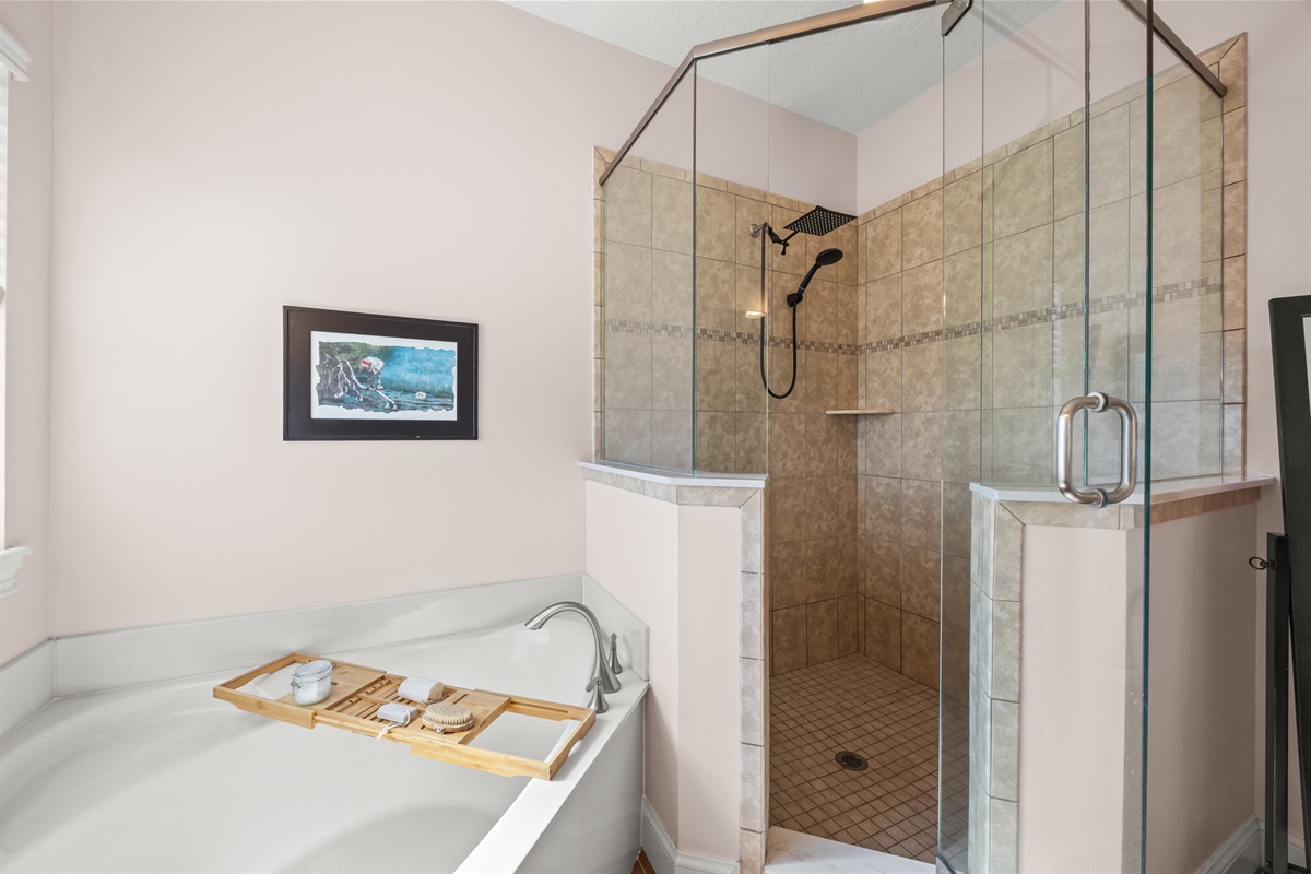 Modern bathroom featuring soaking tub with wooden tray and walk‑in glass shower in coastal Jacksonville Beach Home.