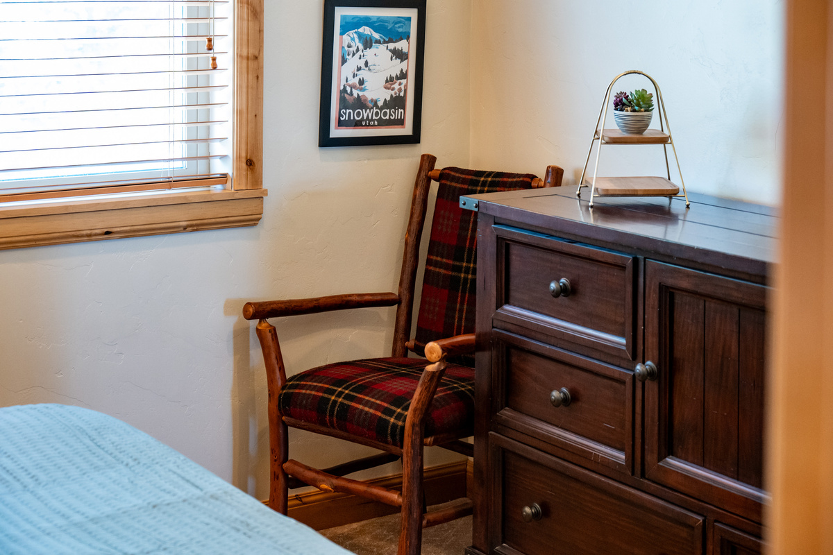 Cozy reading corner and dresser provide comfort and convenience.