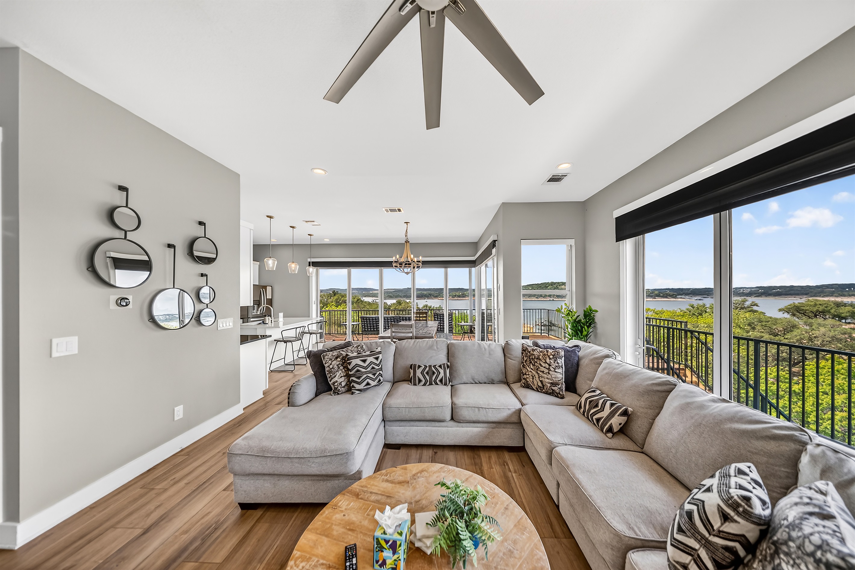 - Bright living room framed by panoramic lakeview windows all around - Cozy sectional seating creates space for gatherings and relaxation - Open layout brings natural light and smooth comfort to every stay