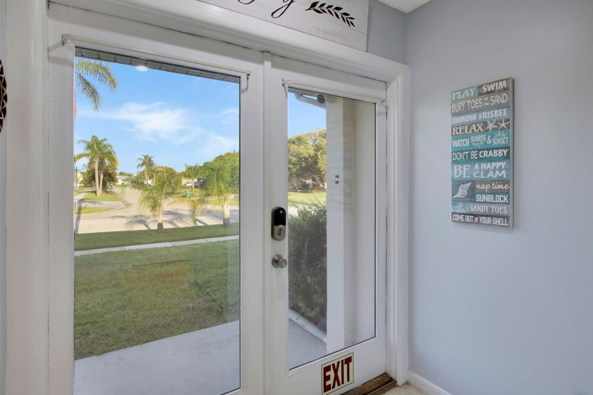 Front door view of neighborhood filled with palm trees and space.