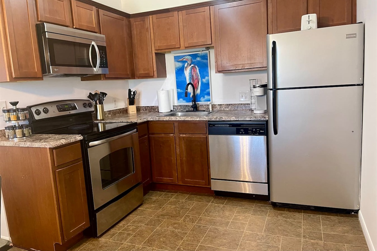 Fully stocked kitchen with stainless steel appliances, spacious counters, a spice rack, Keurig, and modern essentials for home-cooked meals or quick bites. Clean, bright, and functional—perfect for extended stays or cozy nights in.