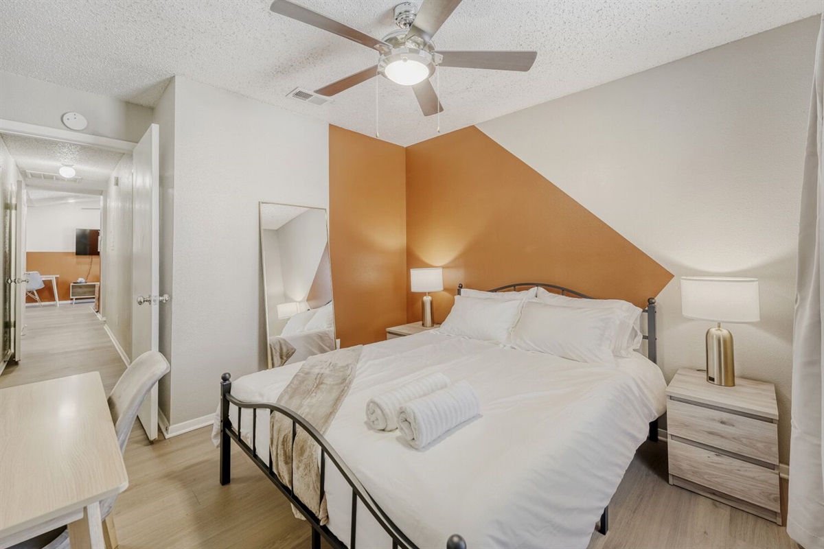 Cozy bedroom with warm tones and a modern geometric accent wall.