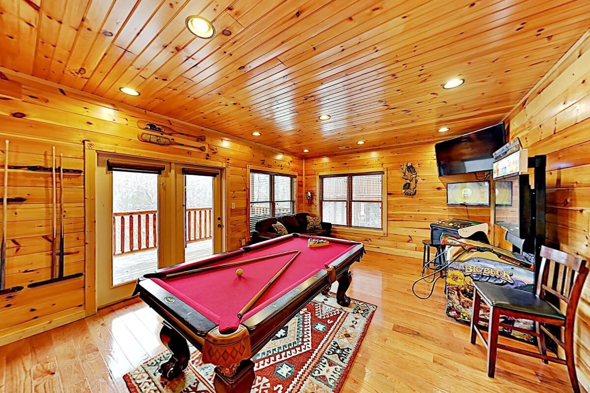 Game room with pool table and arcade games in the basement that both kids and adults will love in the basement.
