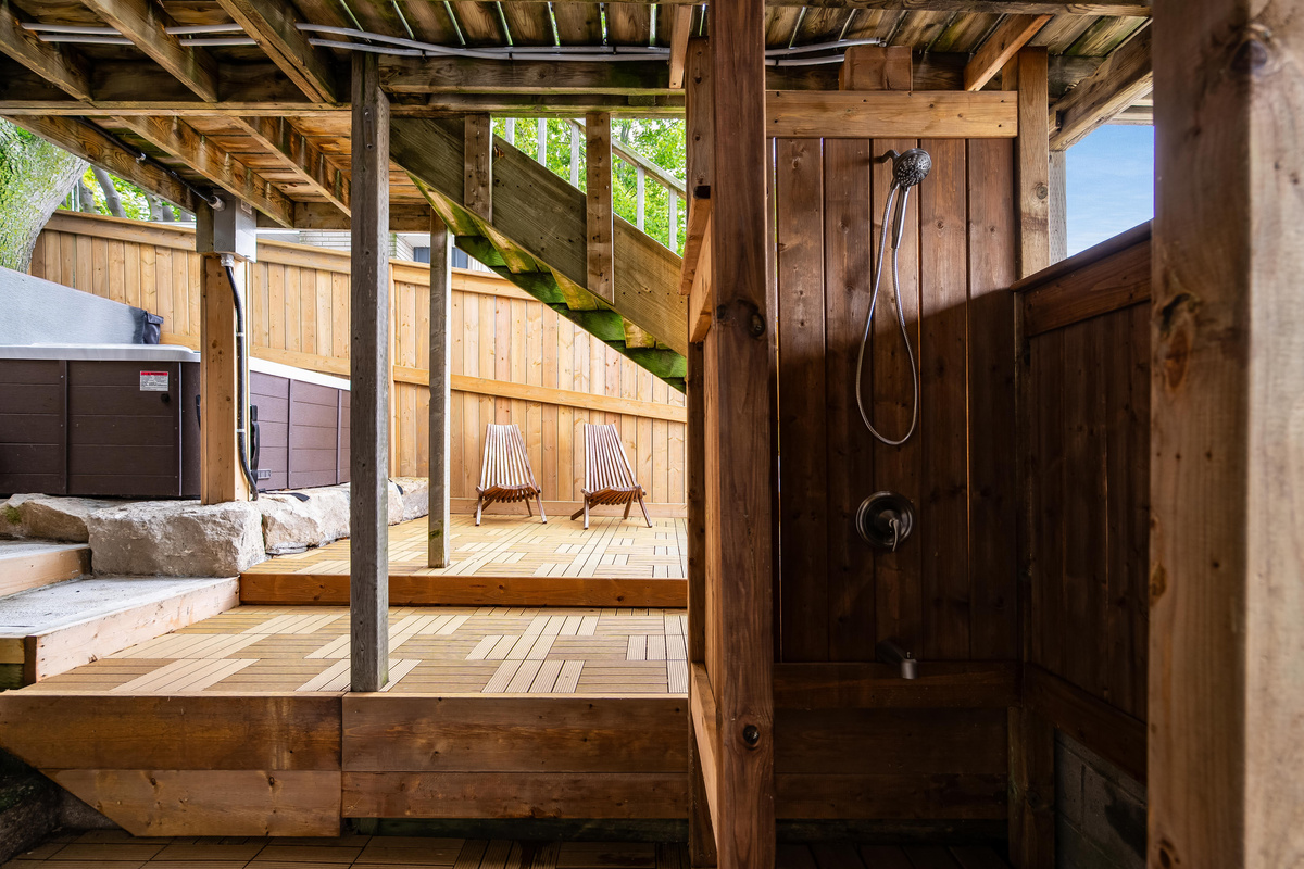 Private outdoor shower area with rustic wood finishes and a spacious deck.