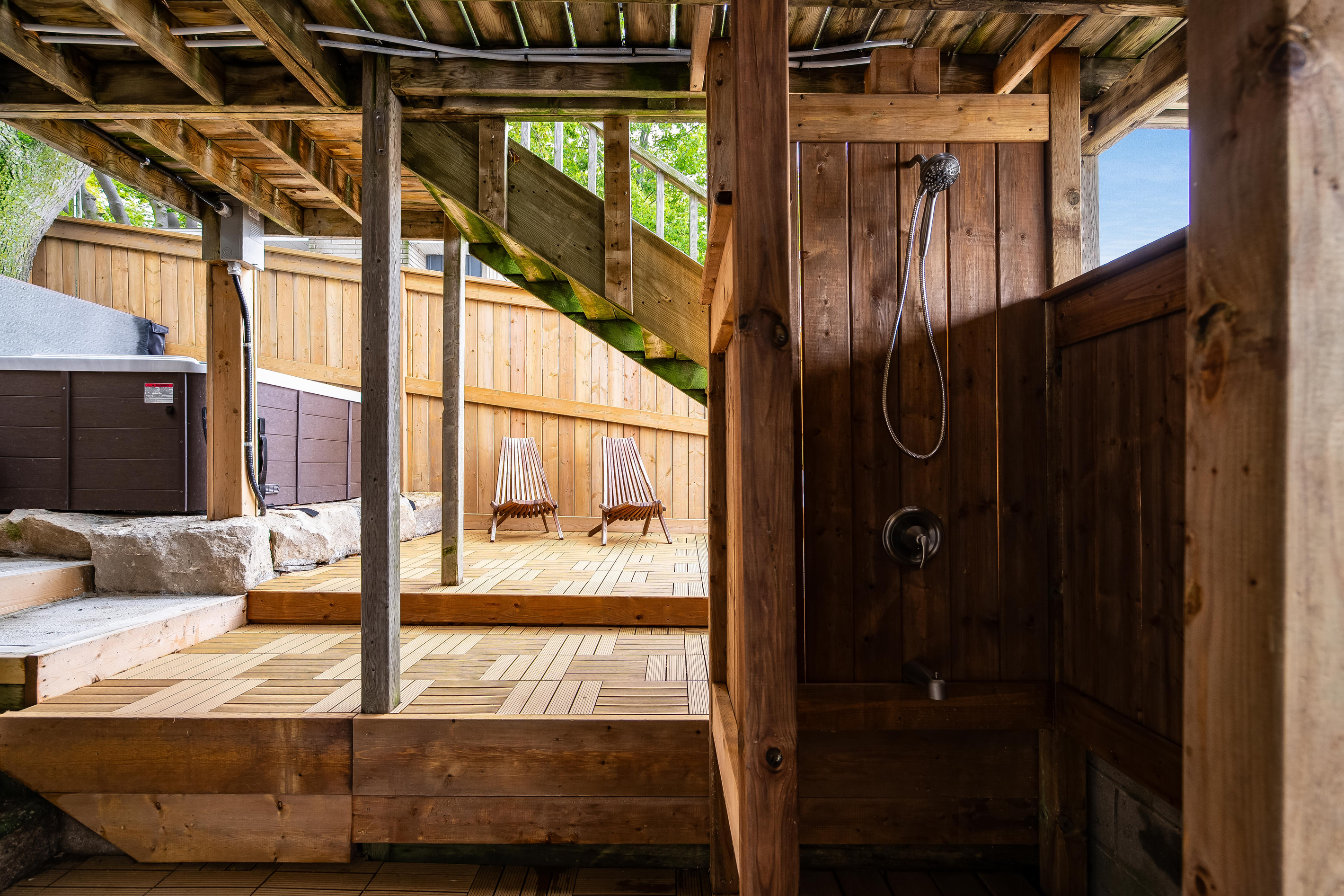 Private outdoor shower area with rustic wood finishes and a spacious deck.