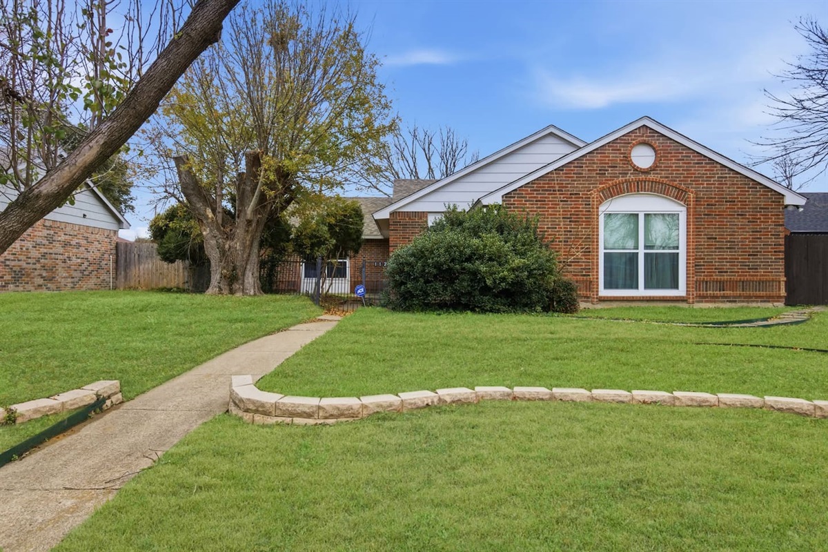 Charming single-story exterior with landscaped yard and quiet residential setting.