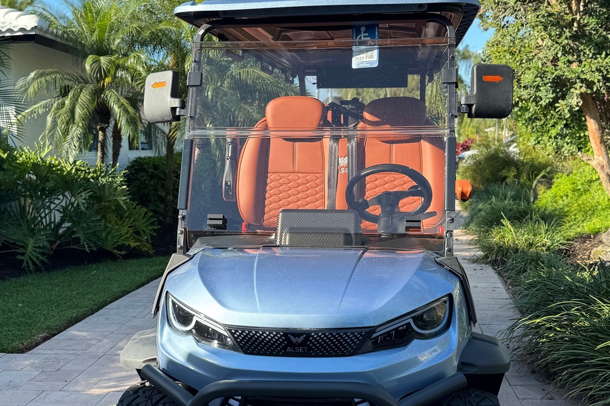 A 6-passenger golf cart with comfortable seating, parked and ready for easy rides around the area.
