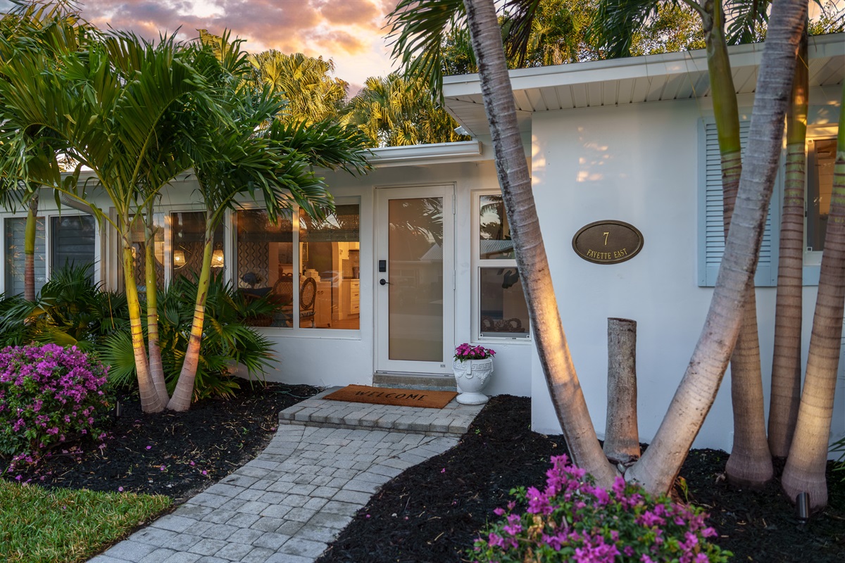 Welcome home. The manicured tropical landscaping and warm entryway lighting offer a five-star arrival experience.