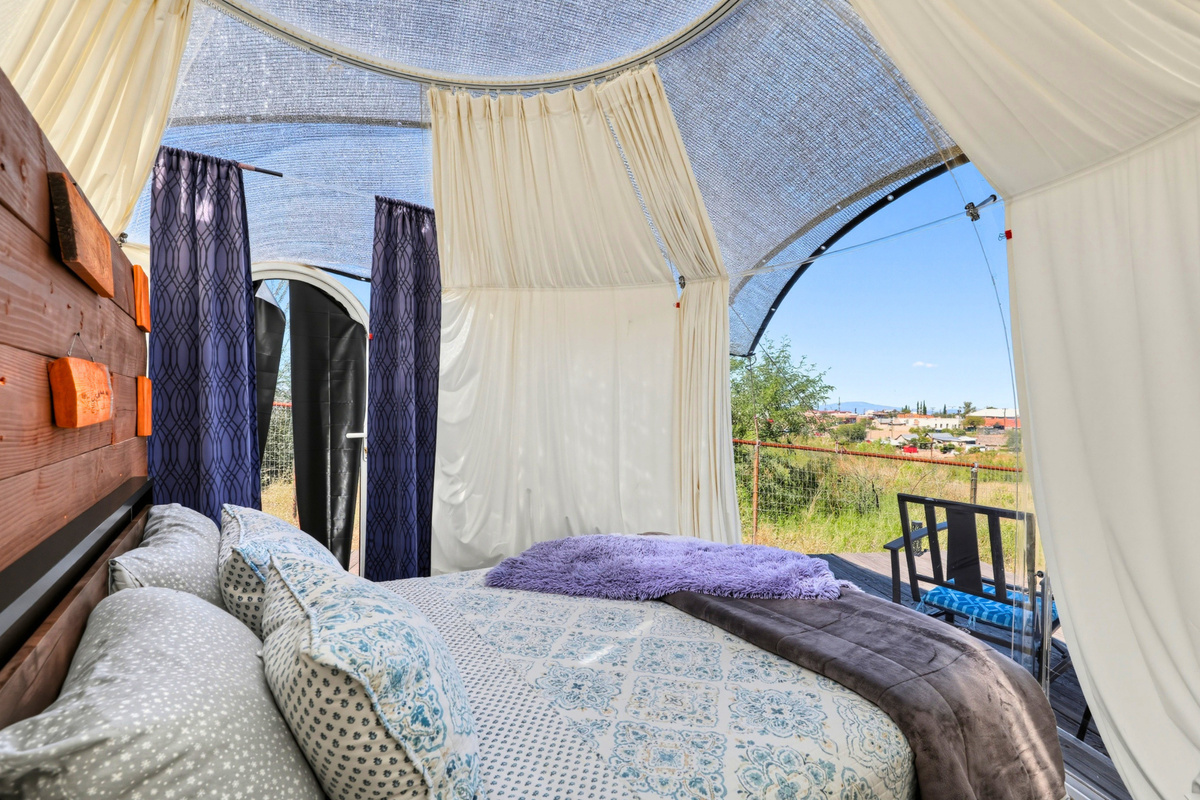 Open the curtains and enjoy the inviting queen bed inside your dome retreat