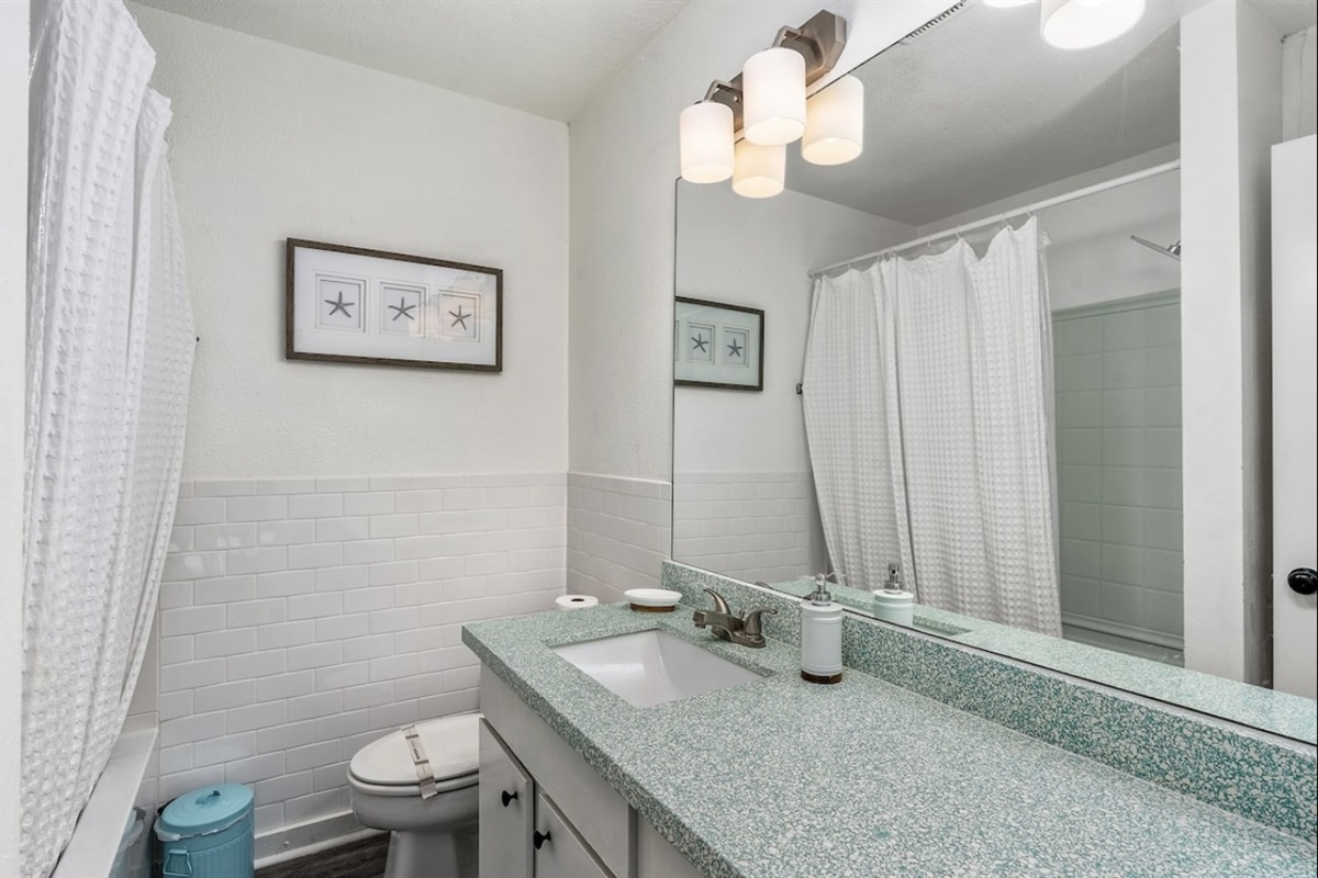 The ensuite master bathroom is gleaming white with a touch of modern design.
