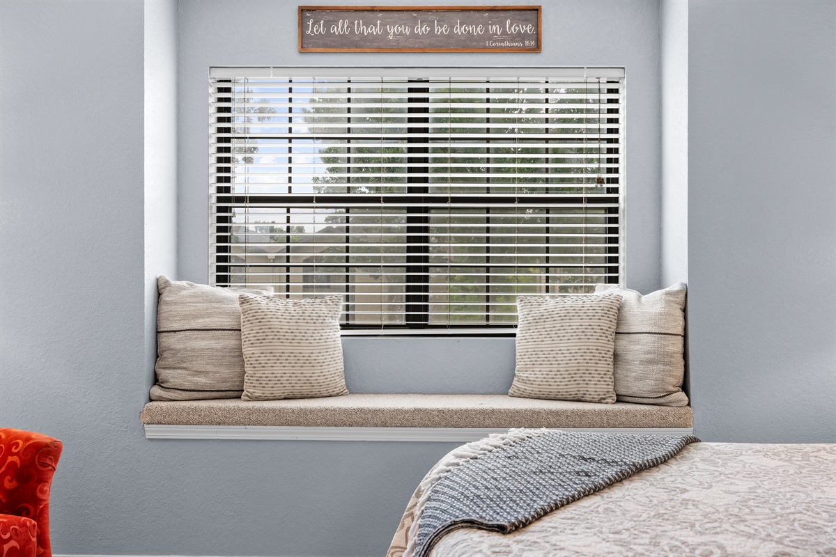 A tucked-in window seat adds a cozy spot to read, scroll, or decompress.