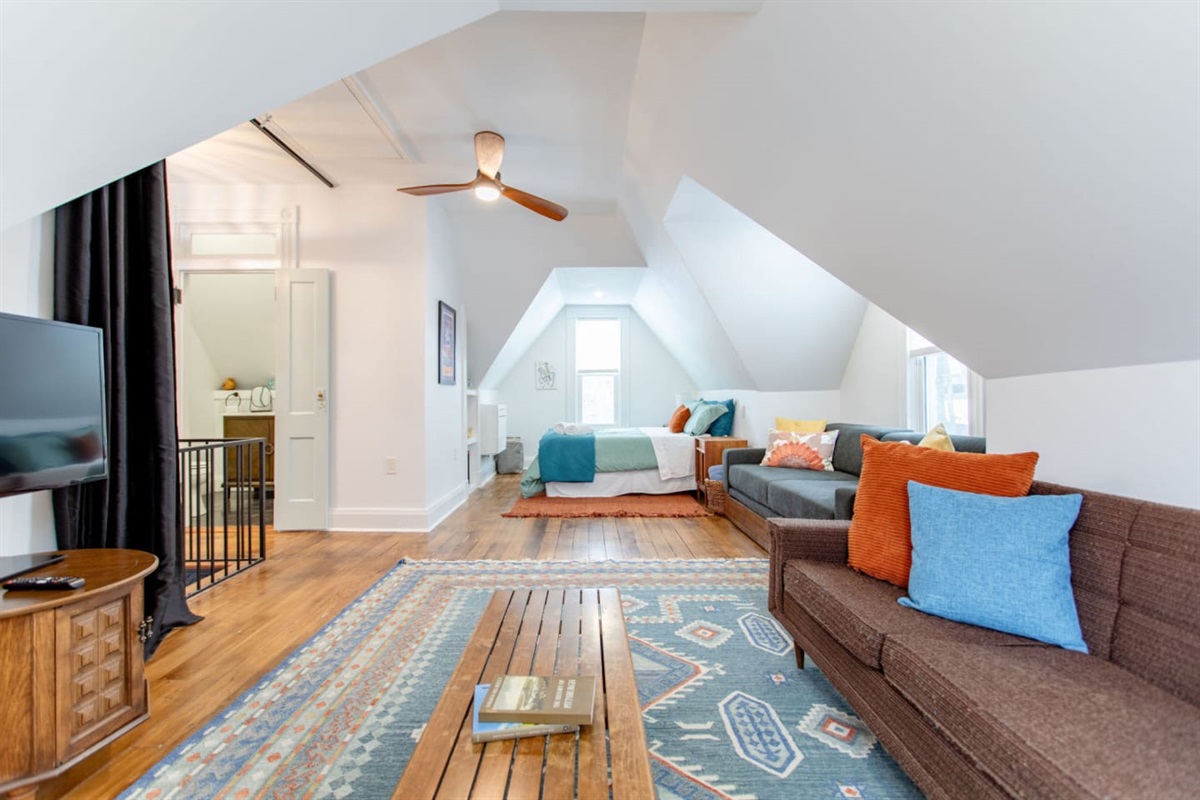 A living area seamlessly integrated into the bedroom, featuring a comfy seating arrangement that allows for both relaxation and a cozy, multi-functional space.