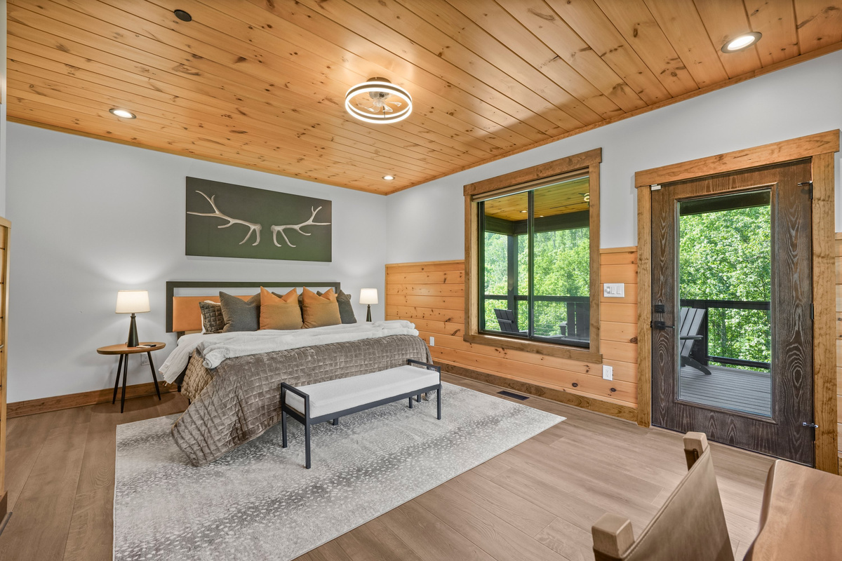 Relax in the spacious king bedroom with a large TV, dedicated desk workspace & direct deck access. Unwind in the en-suite bathroom featuring a walk-in shower with a natural river rock floor, bringing  the Smoky Mountains indoors for a spa retreat.