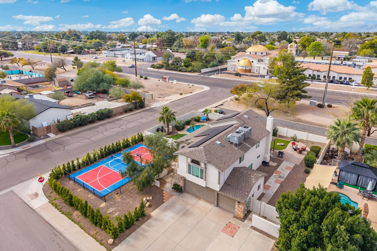 Contemporary home with dedicated sports court, pool, and manicured grounds in established neighborhood.