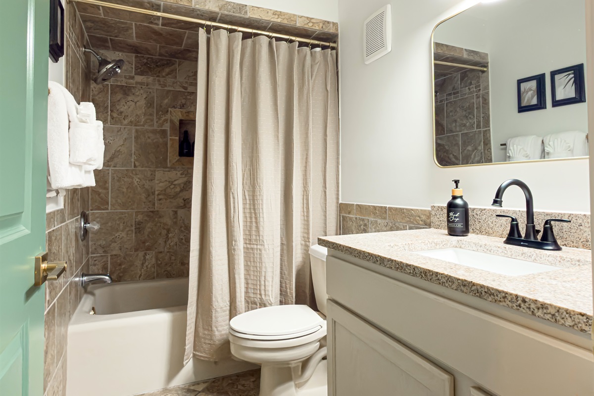 This hall bathroom is easily accessible from the main living areas. The tub makes giving the kids a bath quick and simple.
Guest bathroom offers a tub, fully stocked fluffy towels, washcloths and hand towels along with a bath mat.
