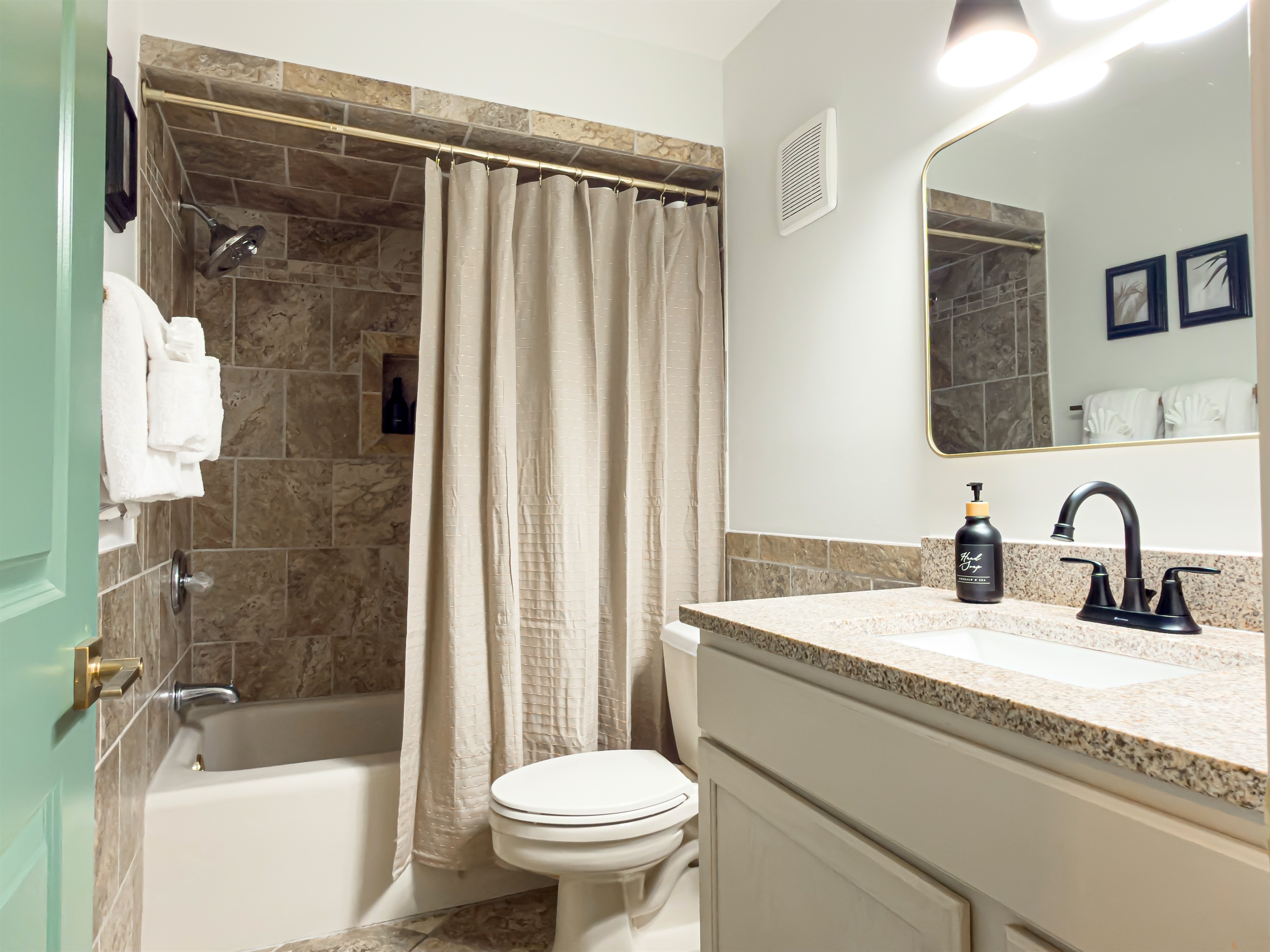 This hall bathroom is easily accessible from the main living areas. The tub makes giving the kids a bath quick and simple.
Guest bathroom offers a tub, fully stocked fluffy towels, washcloths and hand towels along with a bath mat.