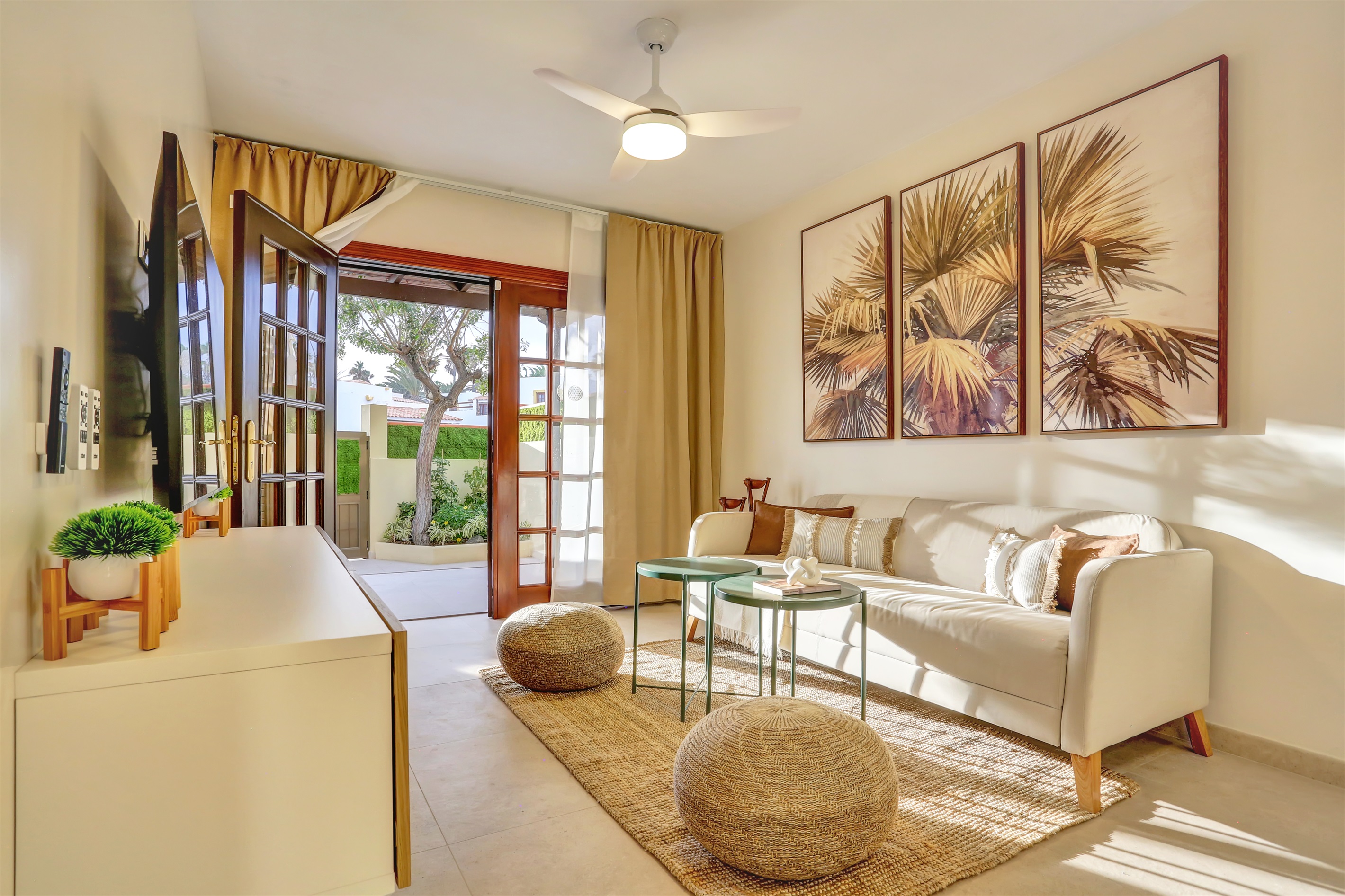 Elegant living room filled with natural light and direct access to the garden, tastefully decorated and designed for a relaxed and comfortable stay.