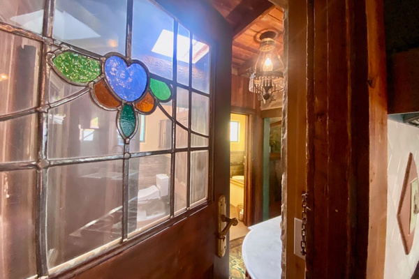 Found forgotten in the shed, this original stained-glass door was restored and returned to service—to separate the kitchen from the dual  powder rooms and laundry area. We love inviting the history back into the story.
