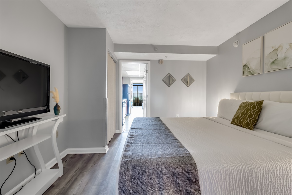 Relax in a spacious and elegantly decorated bedroom with plush bedding and soothing coastal tones.