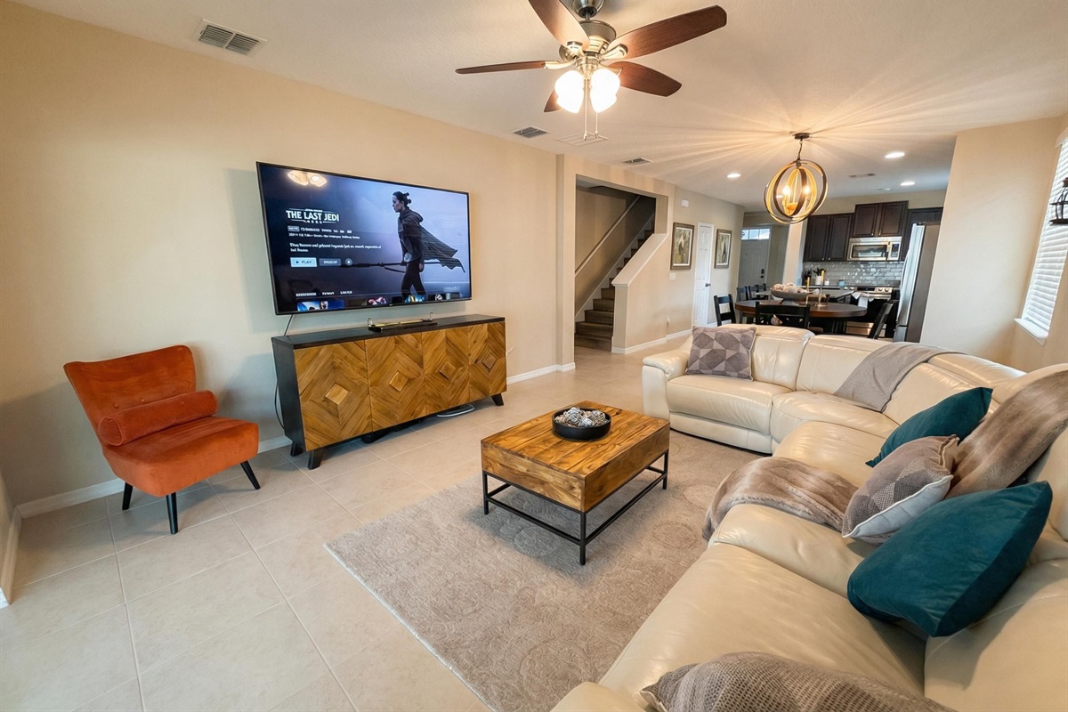 Bright and inviting living room with comfy seating and a large Roku Smart TV.