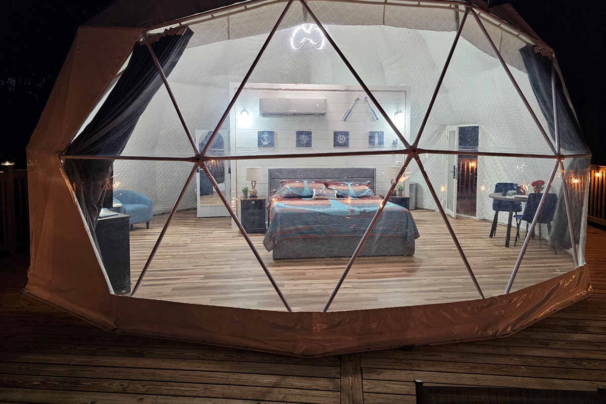 A magical nighttime glow—your private Anchor Dome awaits with cozy lighting and panoramic lake views