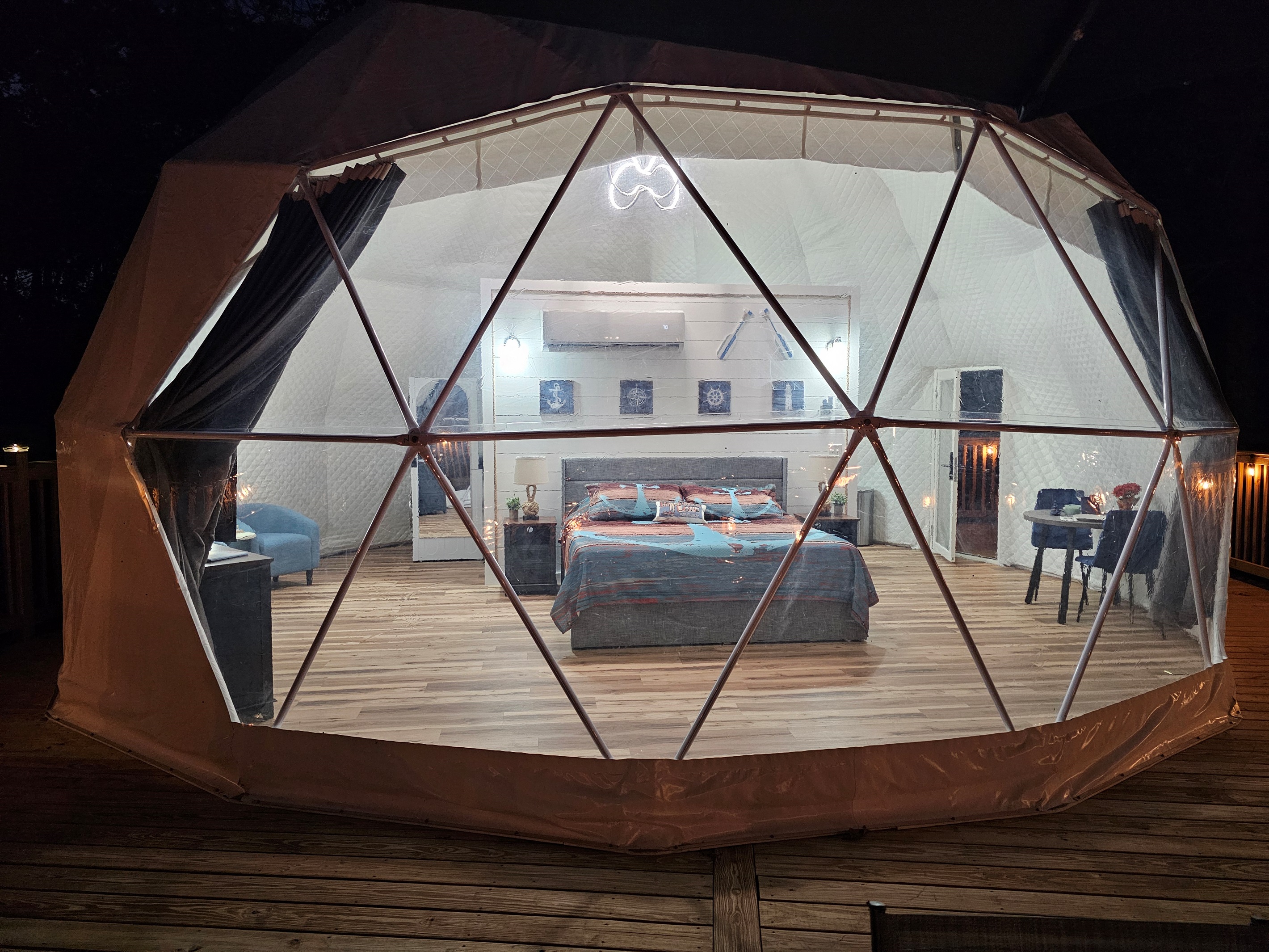 A magical nighttime glow—your private Anchor Dome awaits with cozy lighting and panoramic lake views